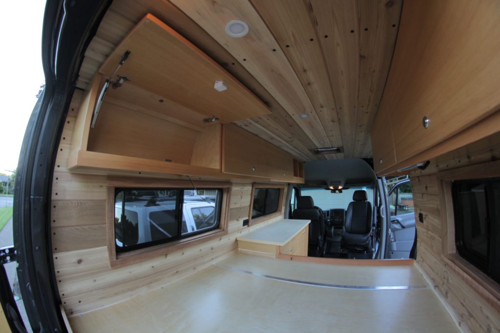 cedar tongue and groove wall and ceiling panels in sprinter camper - van build kitchen design
