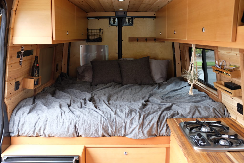completed bedroom of self-converted sprinter camper