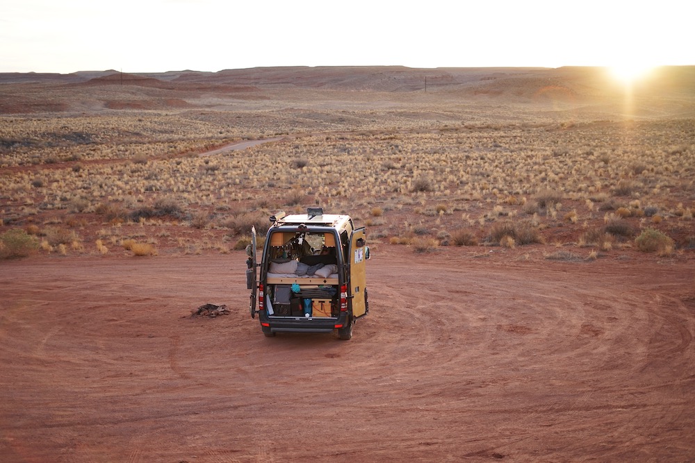 van parked in desert at sunset - top van life apps